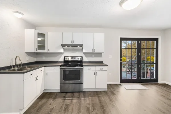 a kitchen with granite countertop a refrigerator stove top oven and sink