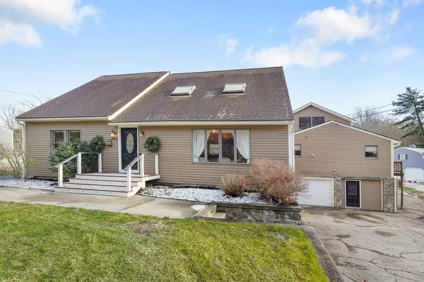 a front view of a house with a garden and plants