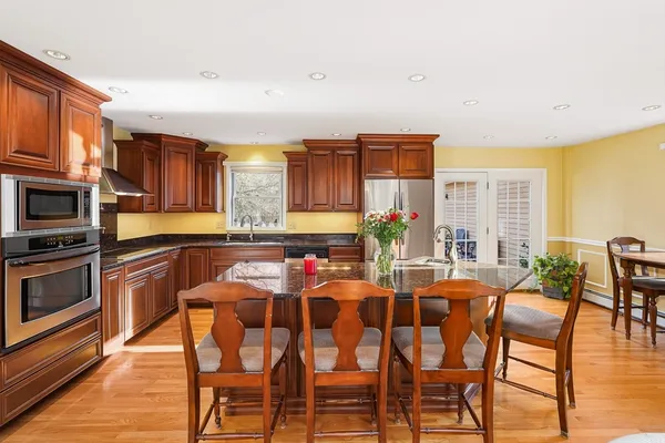 a living room with stainless steel appliances furniture and a kitchen view