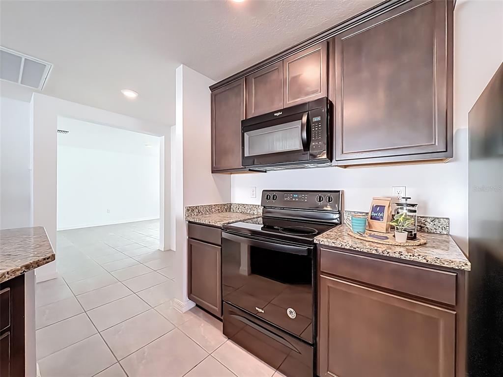 12943 Impatiens Street Spring Hill, FL 34609 - Photo 11 of 53 a kitchen with a stove microwave and sink