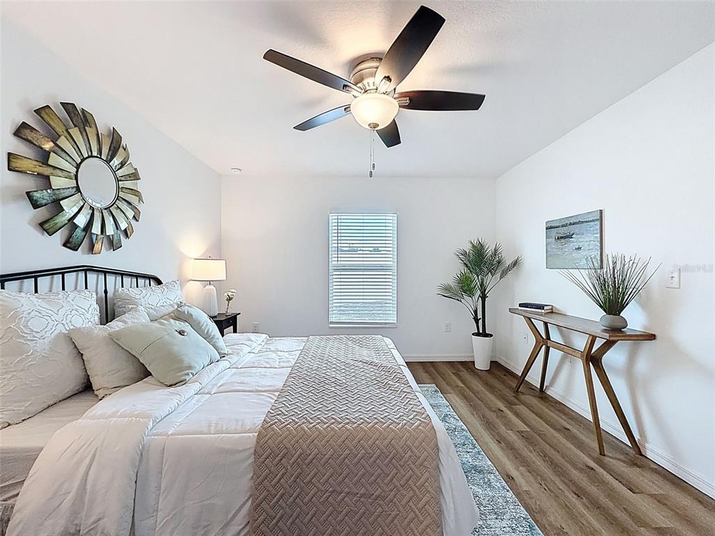 12943 Impatiens Street Spring Hill, FL 34609 - Photo 24 of 53 a bedroom with a bed and a chandelier