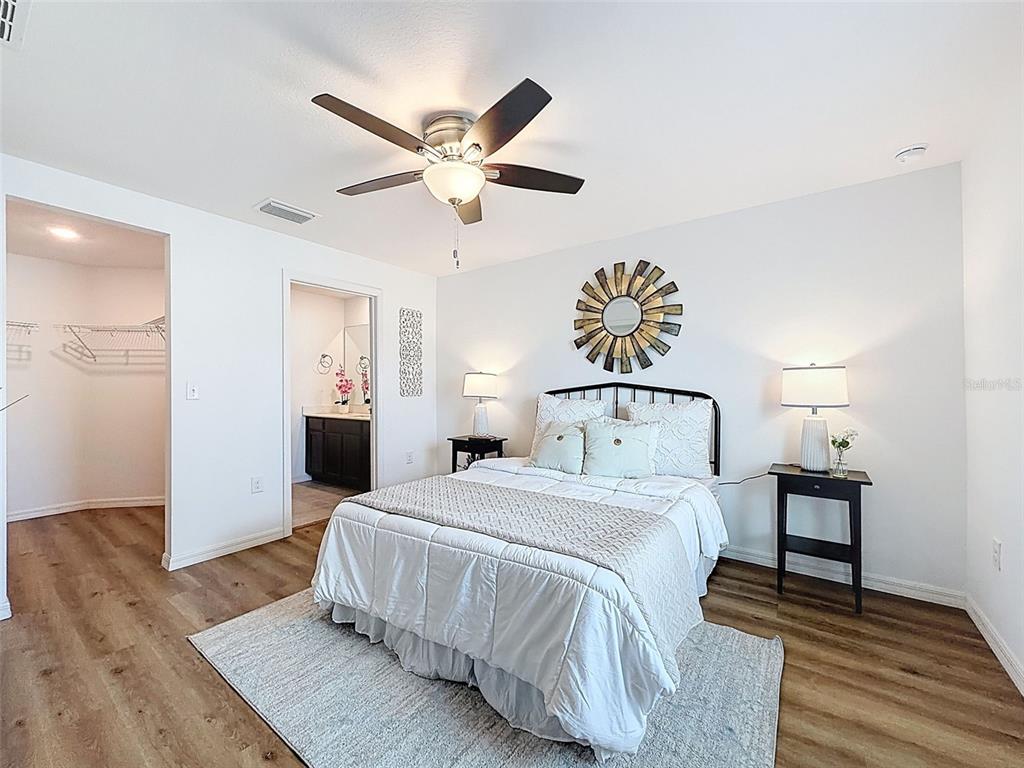 12943 Impatiens Street Spring Hill, FL 34609 - Photo 25 of 53 a spacious bedroom with a bed and a chandelier