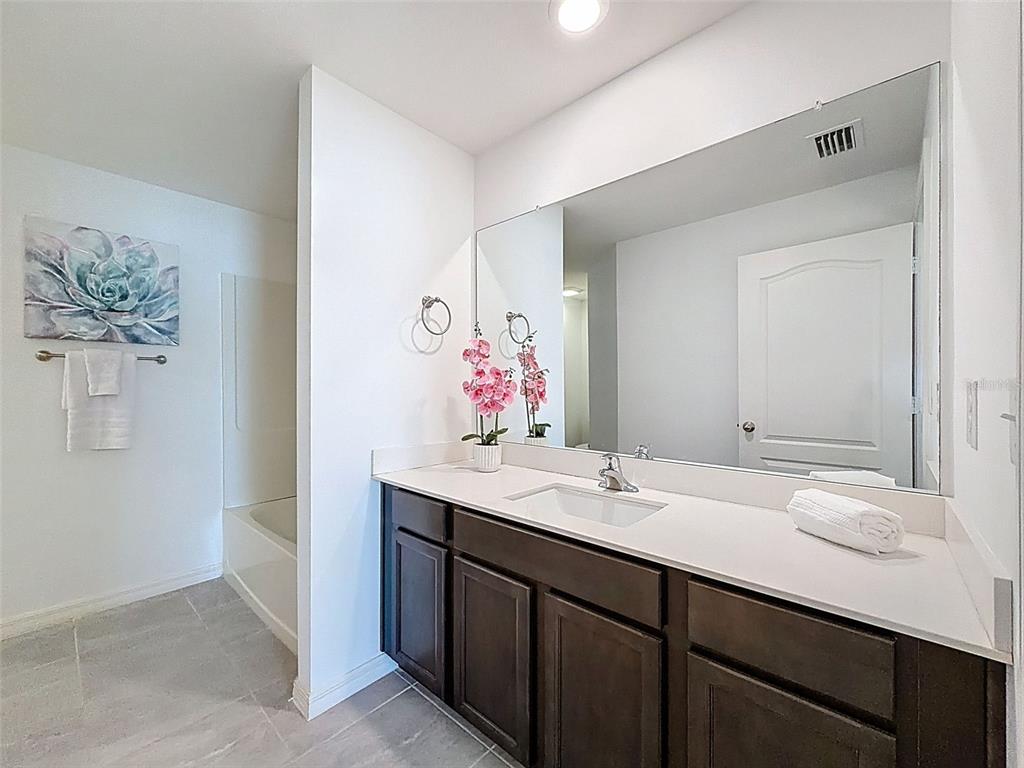 12943 Impatiens Street Spring Hill, FL 34609 - Photo 27 of 53 a bathroom with a double vanity sink and a mirror