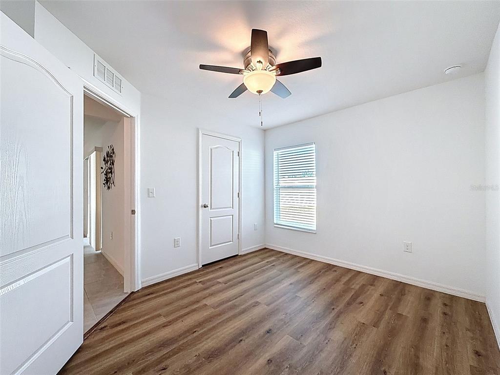 12943 Impatiens Street Spring Hill, FL 34609 - Photo 31 of 53 a view of empty room with wooden floor and ceiling fan