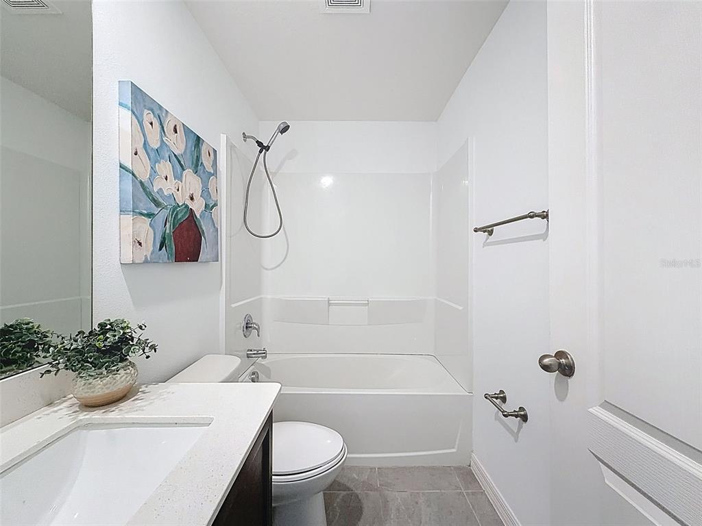 12943 Impatiens Street Spring Hill, FL 34609 - Photo 34 of 53 a bathroom with a toilet a sink and a bathtub