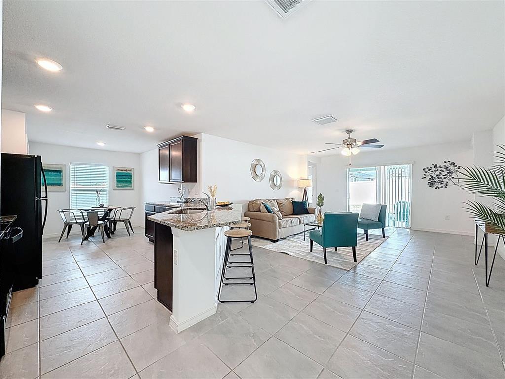 12943 Impatiens Street Spring Hill, FL 34609 - Photo 7 of 53 a living room with furniture a dining table and a fireplace
