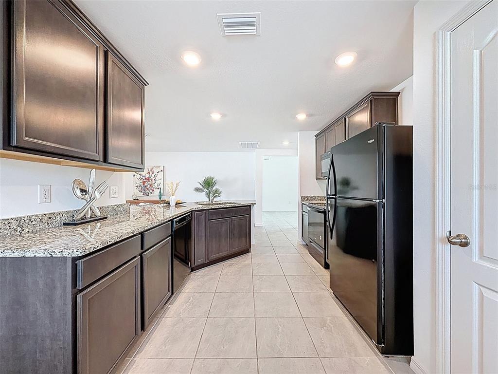 12943 Impatiens Street Spring Hill, FL 34609 - Photo 9 of 53 a large kitchen with a large counter top a sink and stainless steel appliances