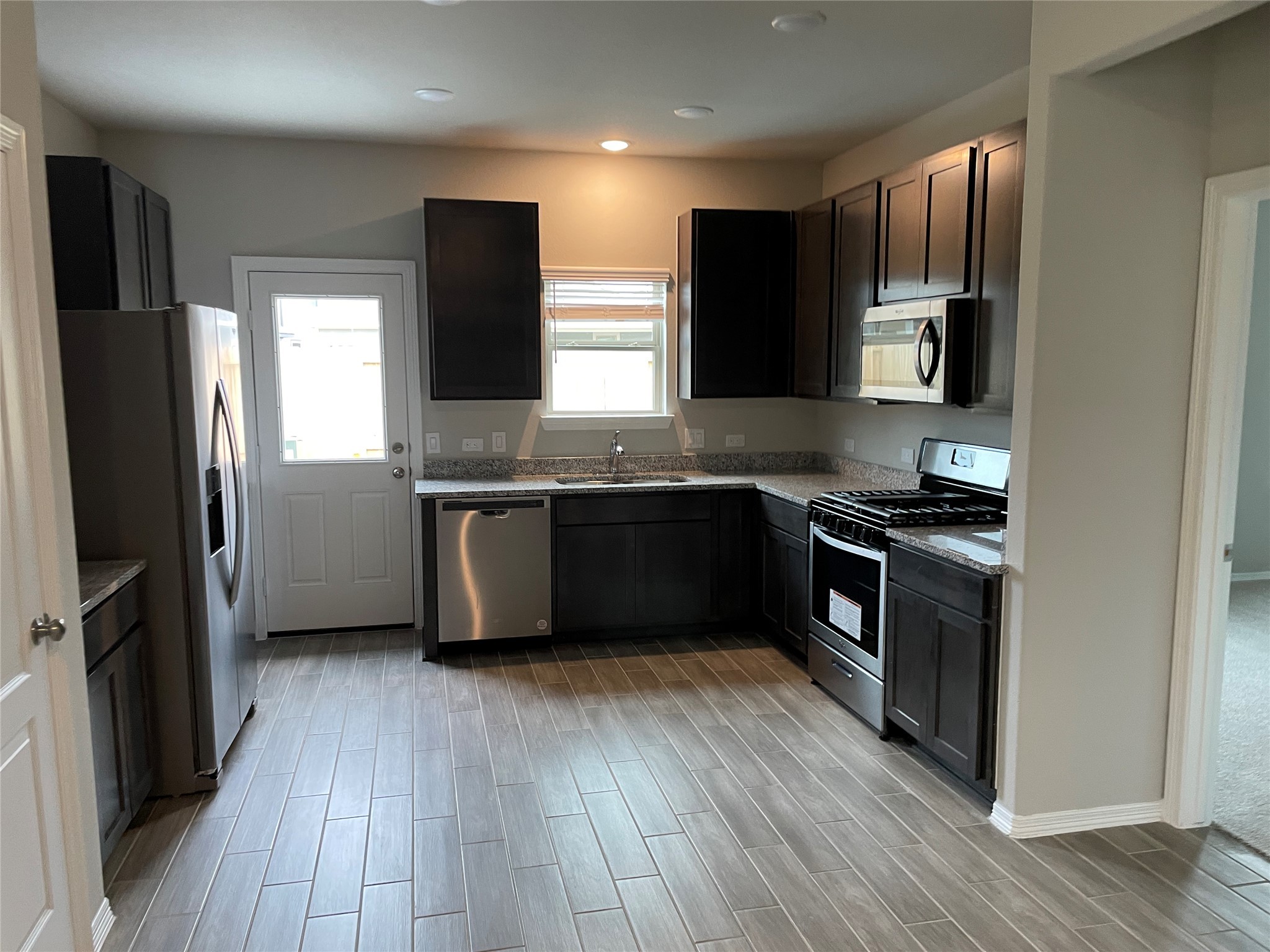 827 Redinger Ridge Drive Huffman, TX 77336 - Photo 6 of 16 a kitchen with stainless steel appliances granite countertop a refrigerator a sink a stove a microwave and cabinets