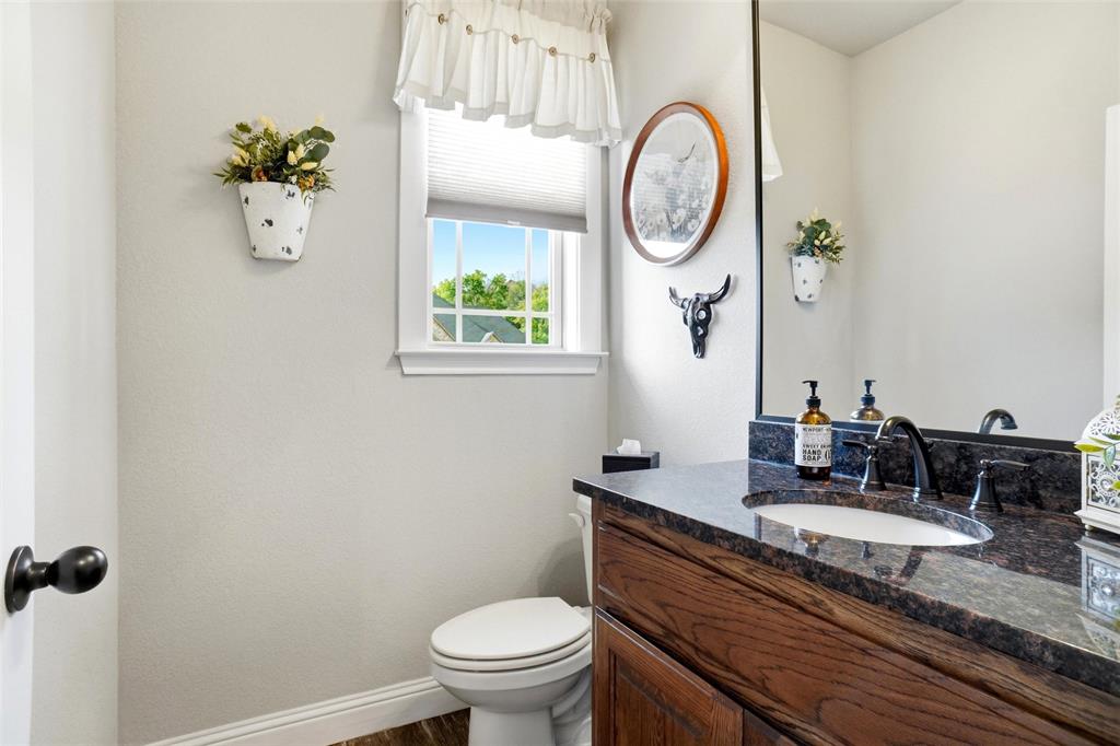 1024 Tex Lane Springtown, TX 76082 - Photo 30 of 40 a bathroom with a granite countertop toilet sink and mirror