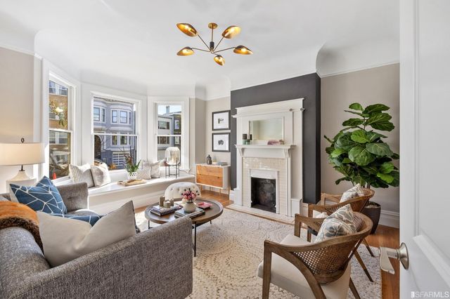 a living room with furniture fireplace and a large window