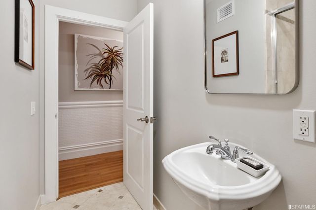 a bathroom with a sink and mirror with toilet