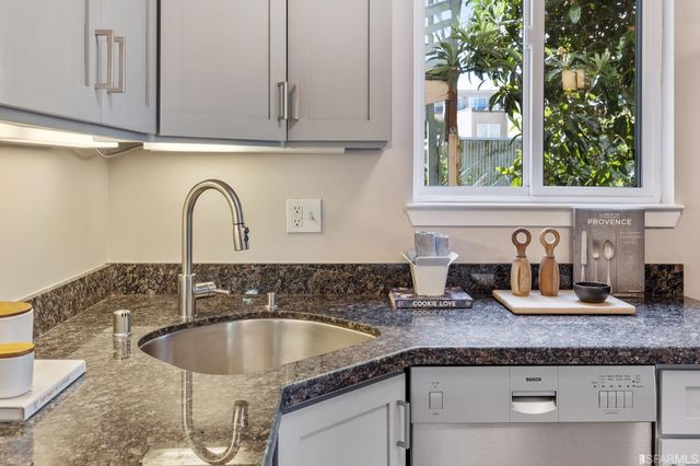 a kitchen with granite countertop a sink and cabinets