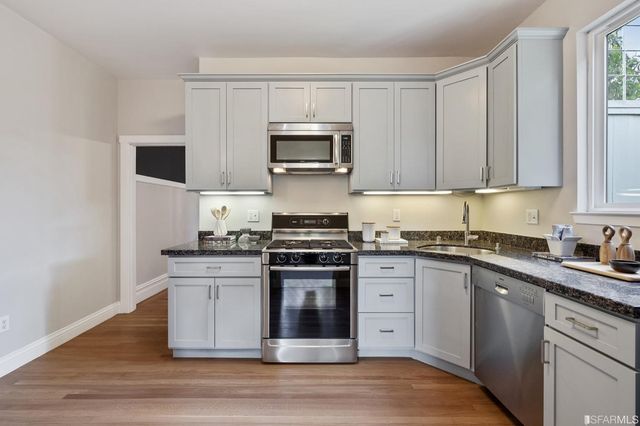 a kitchen with stainless steel appliances granite countertop a stove a sink and a microwave