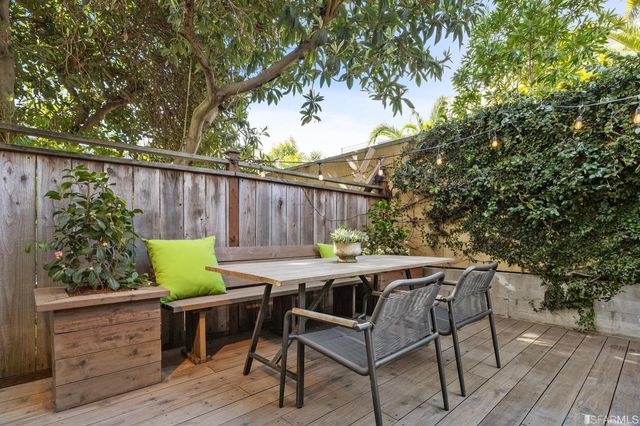 a view of backyard with outdoor seating and wooden fence