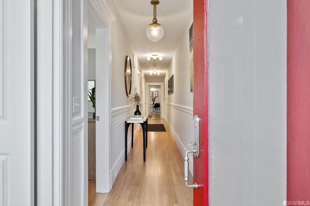 a view of a hallway with wooden floor and staircase