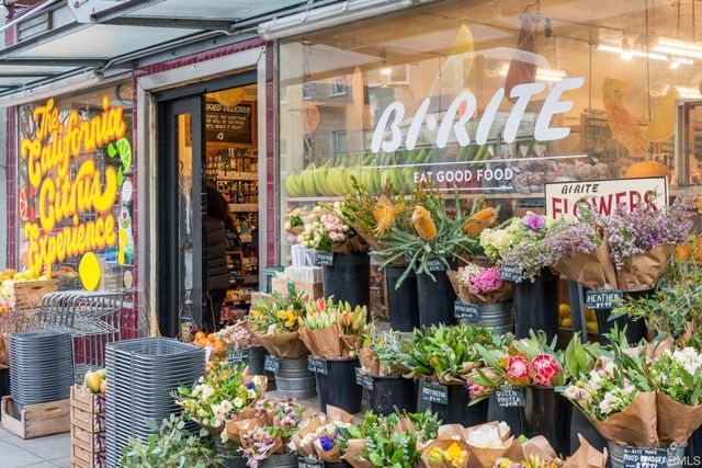 a bunch of flowers in front of shop