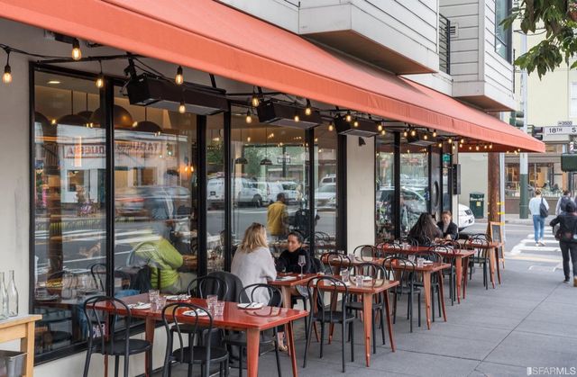 a view of a dining tables and chairs in front of retail shop