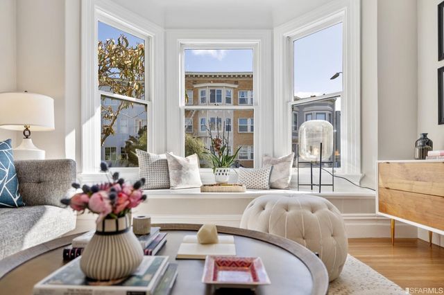a living room with furniture chandelier and a large window