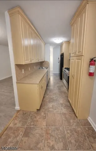 a kitchen with a sink a refrigerator and cabinets