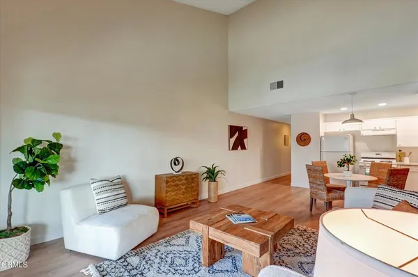 a kitchen with stainless steel appliances a dining table chairs and refrigerator