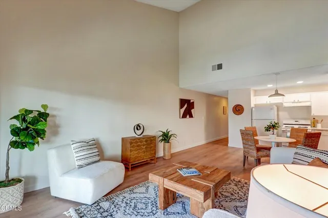 a kitchen with stainless steel appliances a dining table chairs and refrigerator