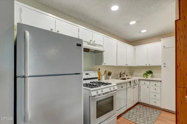 a kitchen with a white cabinets and white appliances