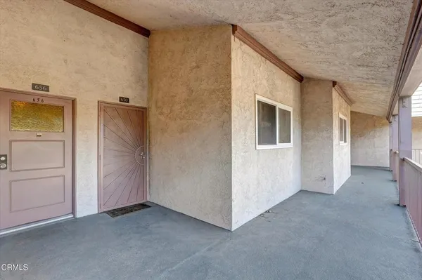 a view of a hallway with wooden floor and a living room