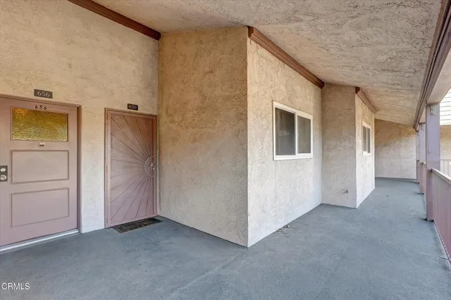 a view of a hallway with wooden floor and a living room
