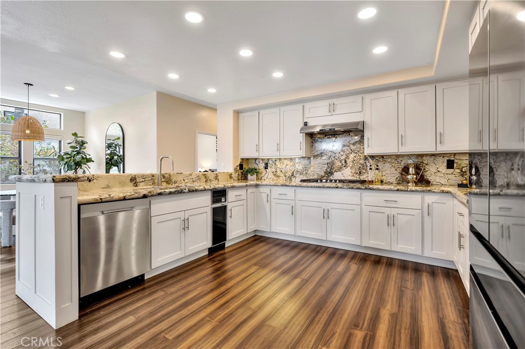 3171 Diamond View Street Corona, CA 92882 - Photo 12 of 49 a kitchen with kitchen island granite countertop wooden cabinets and white appliances