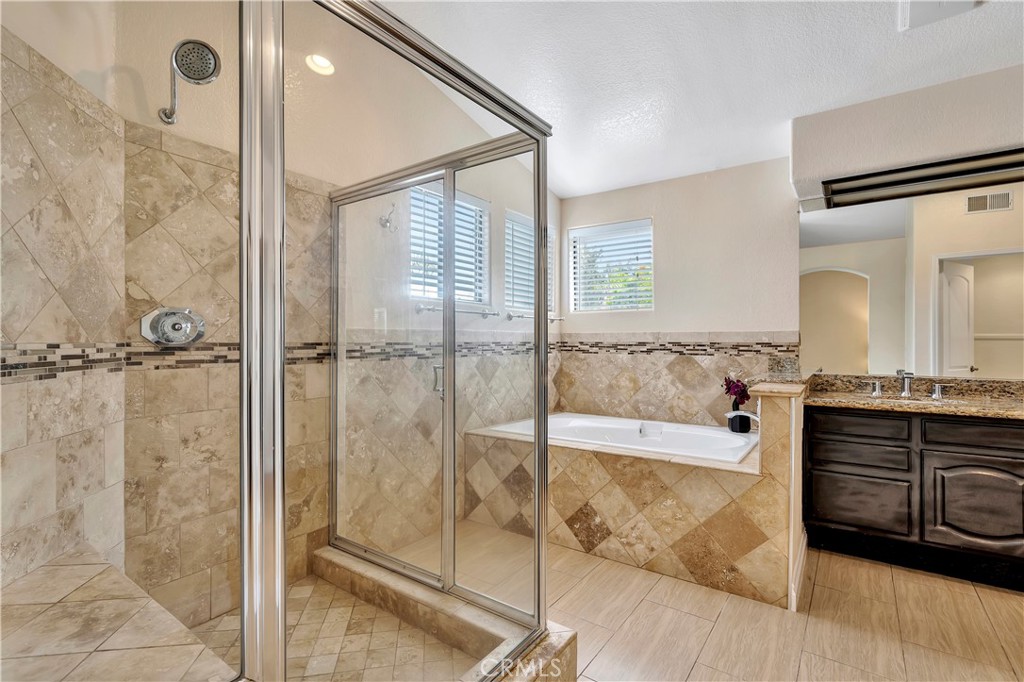 3171 Diamond View Street Corona, CA 92882 - Photo 42 of 49 a spacious bathroom with a granite countertop tub shower and mirror