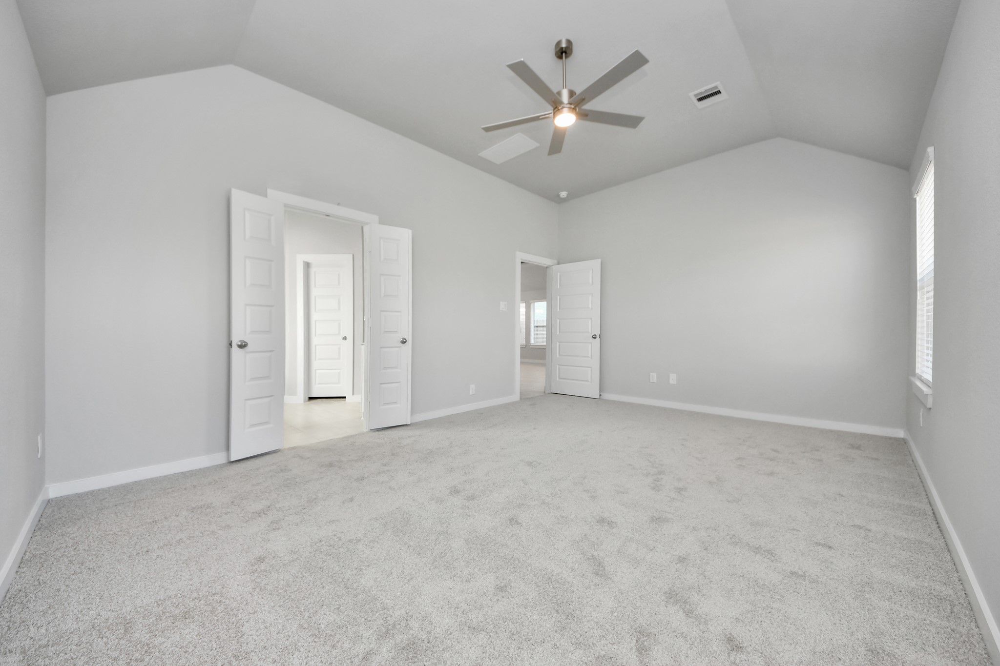 311 Ice Shr Trail Dayton, TX 77535 - Photo 22 of 35 Come and unwind after a long day in this magnificent primary suite! This spacious room features plush carpet, warm paint, high ceilings and large windows with privacy blinds. Sample photo of completed home with similar floor plan. Actual colors and selections may vary.