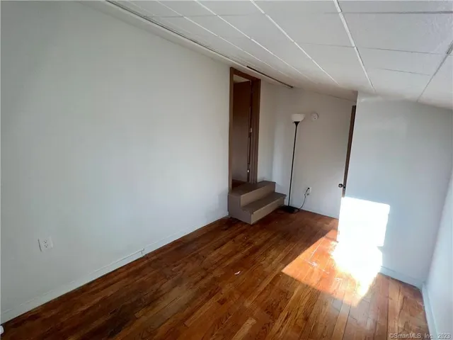 a view of an empty room and wooden floor