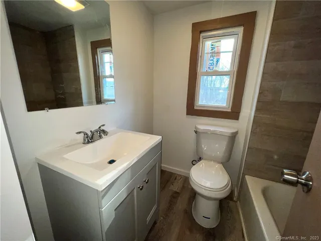a bathroom with a toilet sink and mirror
