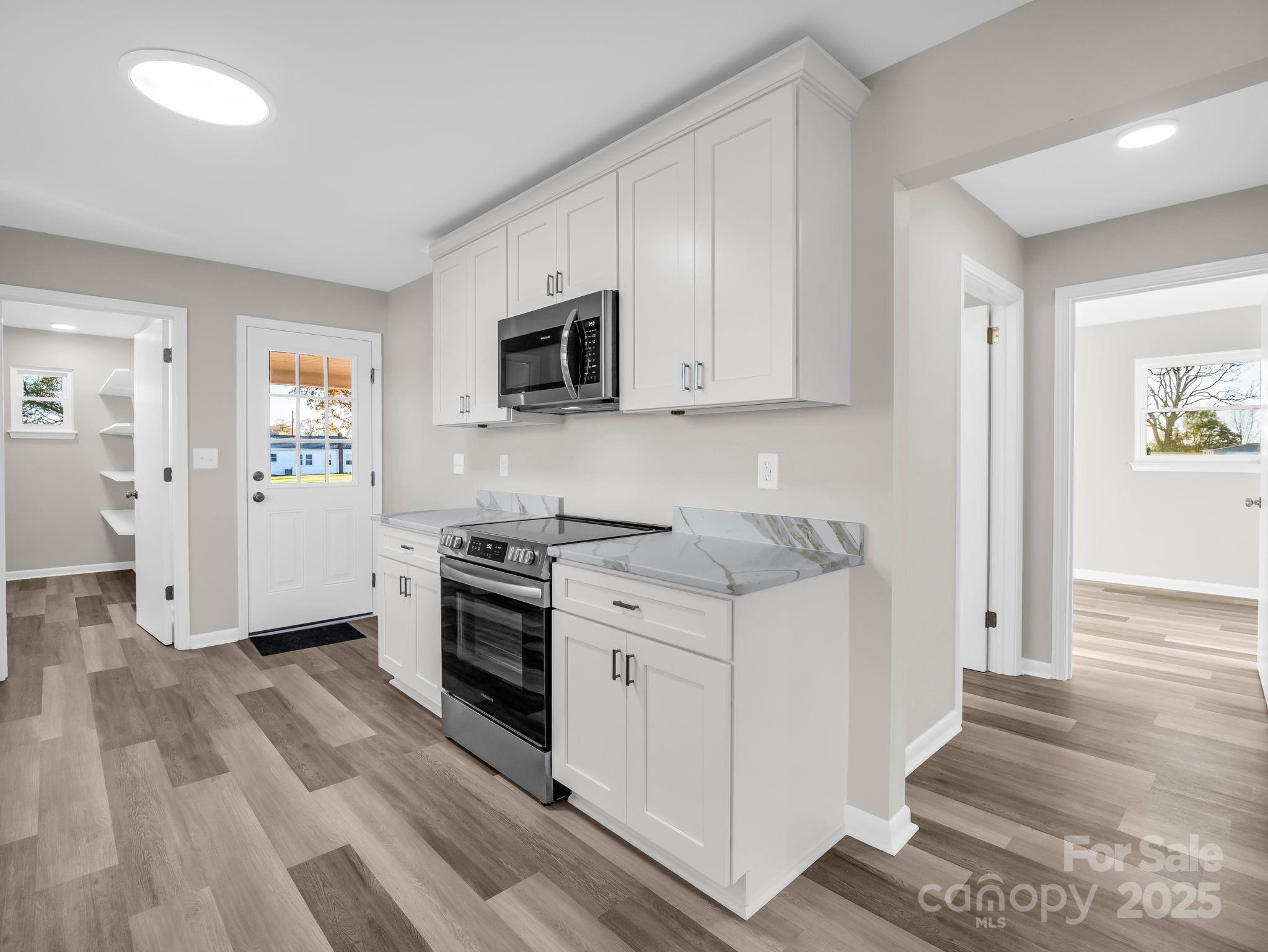 1696 Race Path Church Road Mooresboro, NC 28114 - Photo 11 of 31 a kitchen with stainless steel appliances a stove microwave and sink