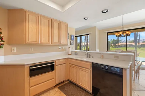 a kitchen with granite countertop a sink and white cabinets