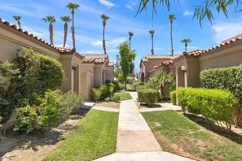 a view of a house with a yard and potted plants