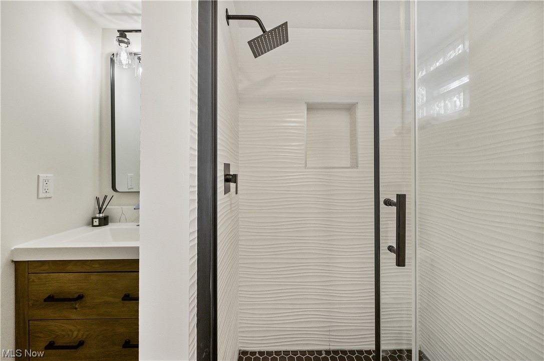 1606 Maple Road Cleveland Heights, OH 44121 - Photo 26 of 30 Partially finished basement offers options for family/recreation room or working space and renovated full bathroom(2023) with walk-in shower, sliding shower door and single vanity