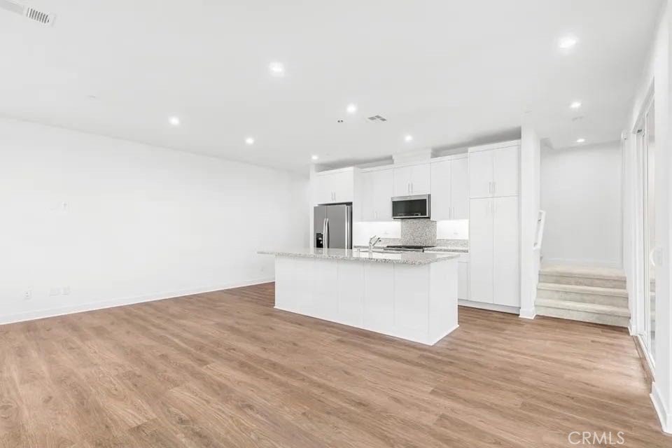 1831 West Bushell Street Anaheim, CA 92805 - Photo 1 of 1 a view of kitchen with kitchen island stainless steel appliances refrigerator stove microwave and cabinets