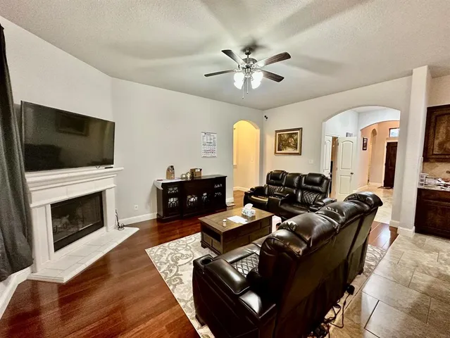 a living room with furniture a fireplace and a flat screen tv