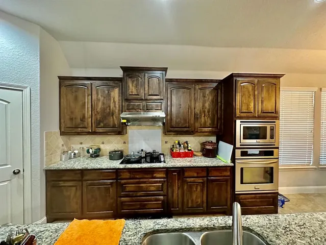 a kitchen with wooden cabinets and refrigerator