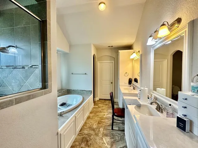 a bathroom with a tub sink and mirror