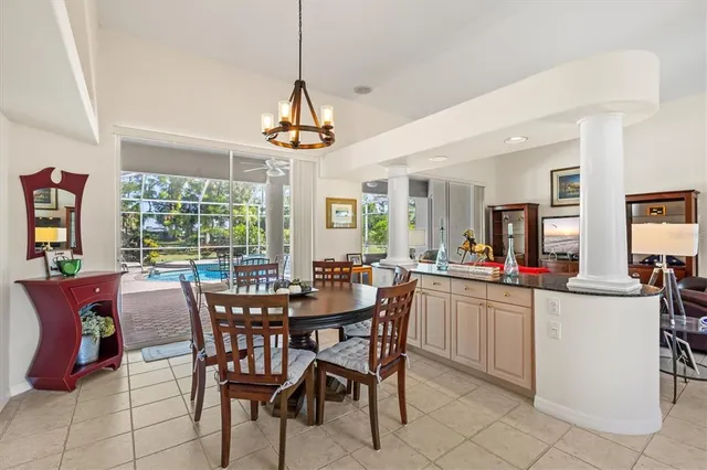a kitchen with stainless steel appliances kitchen island granite countertop a refrigerator a stove a sink dishwasher a dining table and chairs with wooden floor
