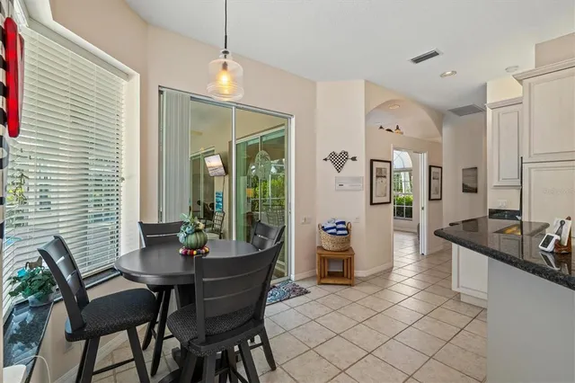 a kitchen with stainless steel appliances granite countertop a sink a stove a refrigerator cabinets and chairs