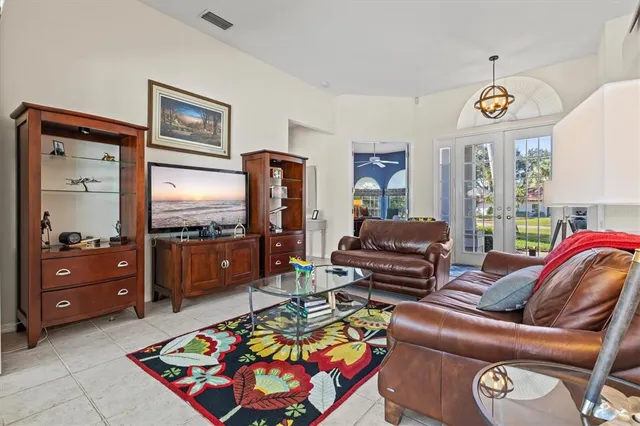 a view of a dining room and livingroom with furniture wooden floor a chandelier