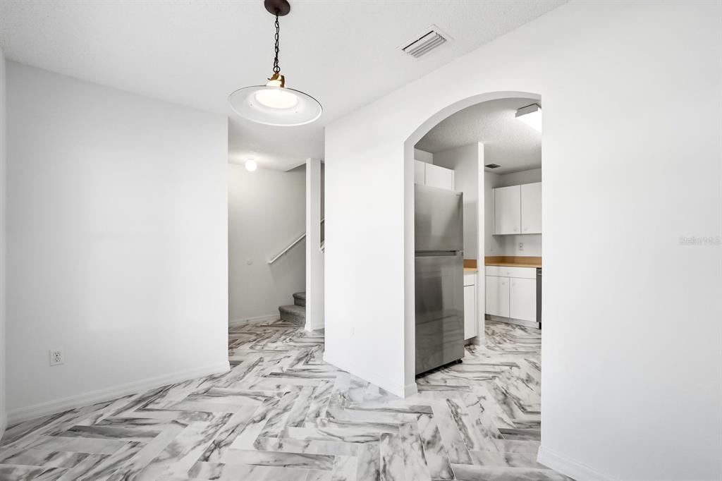 1502 Deer Springs Road Port Orange, FL 32129 - Photo 7 of 35 a view of a hallway with a chandelier and a bath room