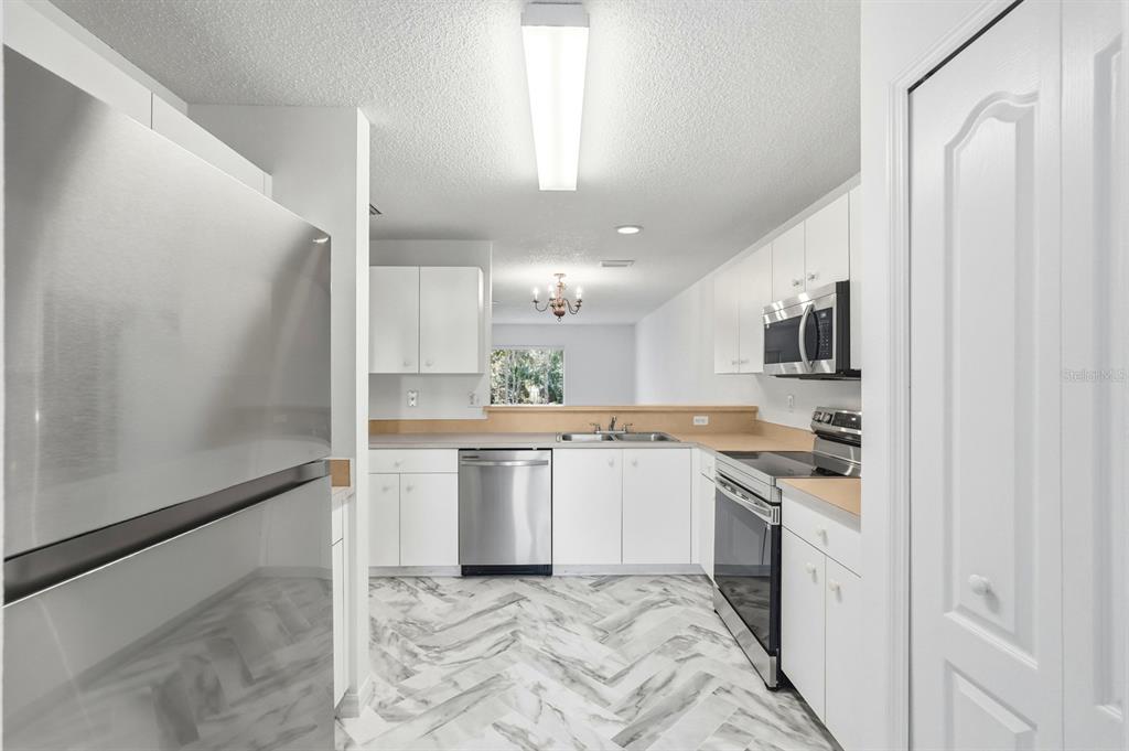 1502 Deer Springs Road Port Orange, FL 32129 - Photo 8 of 35 a kitchen with white cabinets and white appliances