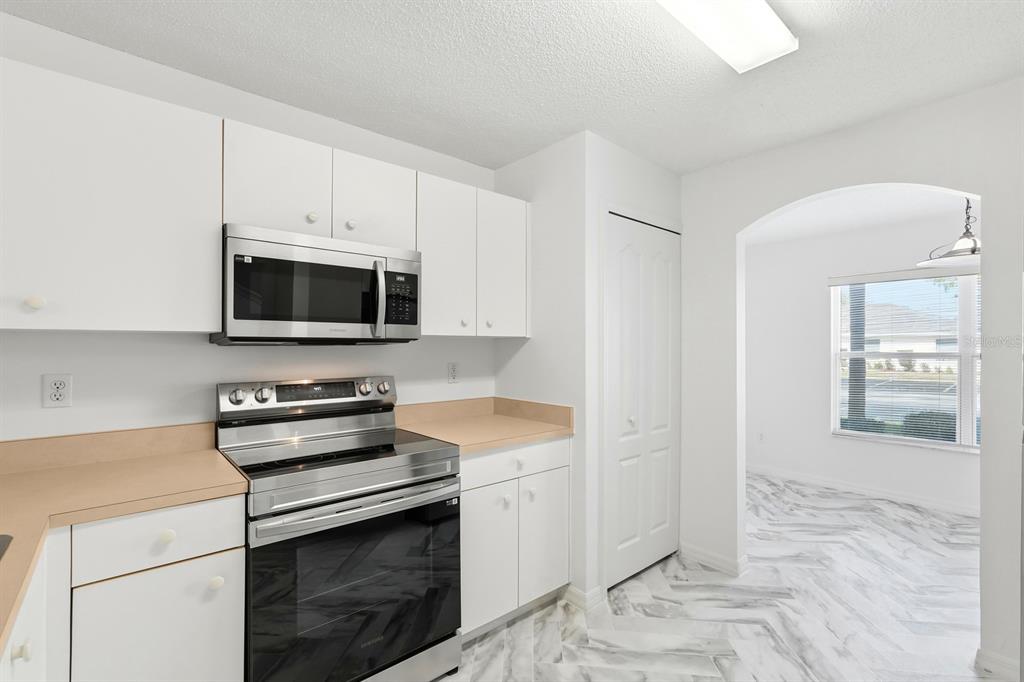 1502 Deer Springs Road Port Orange, FL 32129 - Photo 9 of 35 a kitchen with granite countertop white cabinets and white appliances