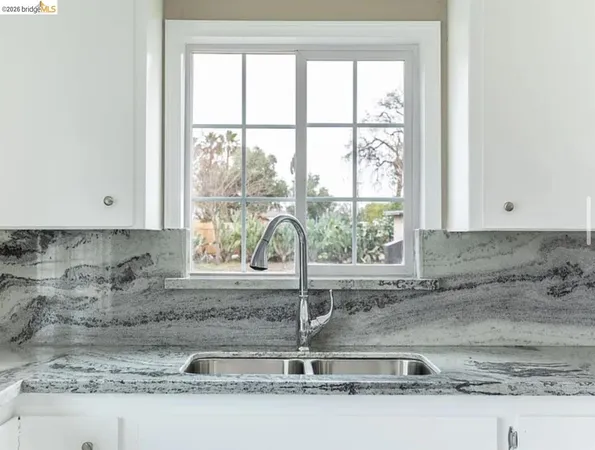 a kitchen with a sink a counter top and cabinets