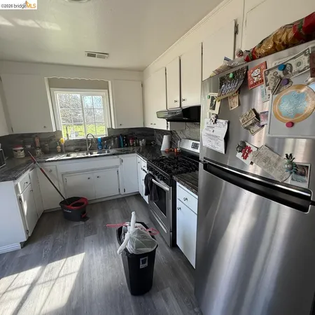 a kitchen with stainless steel appliances granite countertop a sink stove and cabinets