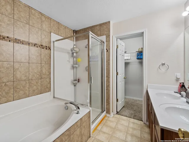 a bathroom with a tub shower sink and mirror